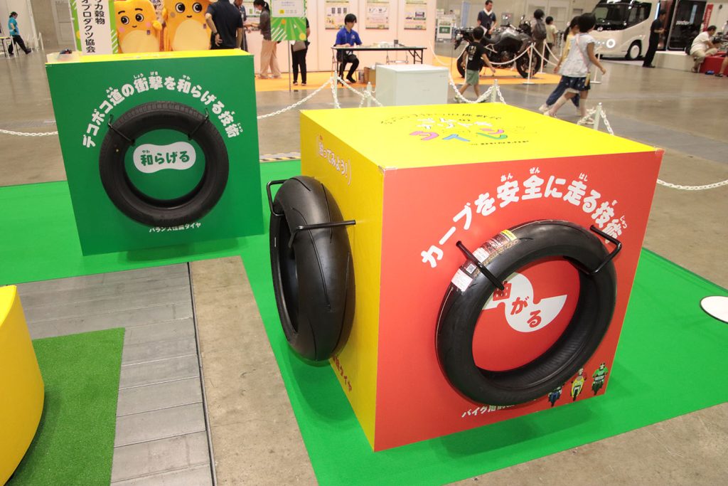 「和らげる」技術と「ル・マンファイブプラス」(奥)、「曲がる」技術と二輪用ハイグリップタイヤ「スポーツマックスQ5」(手前)